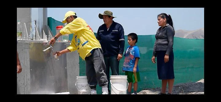 Residents collecting water from UTEC’s humidity-condensing billboard installation. Contemporary photograph in UTEC’s February 2013 launch announcement.